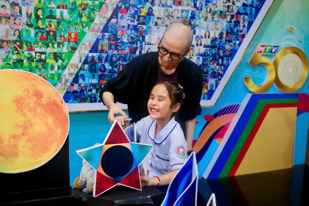 Dưới sự hướng dẫn tận tình của Ban tổ chức, các em nhỏ khiếm thị được trực tiếp chạm tay, cảm nhận hình dáng sân khấu, từ đó hình dung rõ ràng hơn về những điều sắp diễn ra tro.jpg