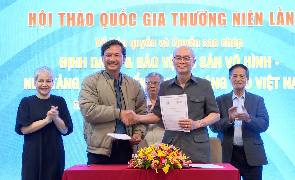 Phó Tổng Biên tập phụ trách Báo và Phát thanh - Truyền hình An Giang Lê Văn Chuyển (bìa trái) và ông Hoàng Trọng Quang, Chủ tịch Hiệp hội Quyền sao chép Việt Nam đã ký kết thỏa thuận hợp tá.jpg
