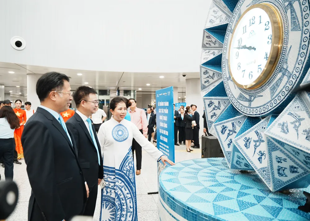 Các đại biểu, khách mời tham quan tác phẩm nghệ thuật Đồng hồ gốm đặt tại khu vực giếng trời của ga Bến Thành