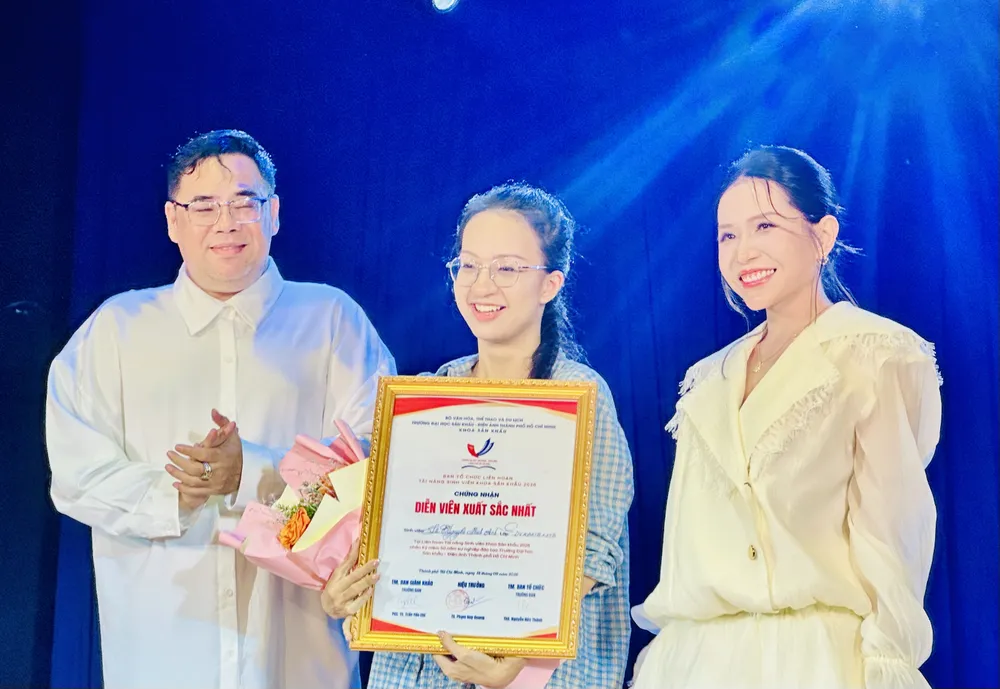 NSƯT - Đạo diễn Lê Nguyên Đạt, Phó Hiệu trưởng Trường Đại học Sân khấu - Điện ảnh TPHCM và diễn viên Khả Như trao giải Diễn viên xuất sắc cho sinh viên Lê Nguyễn Minh Anh. Ảnh: THANH HIỆP