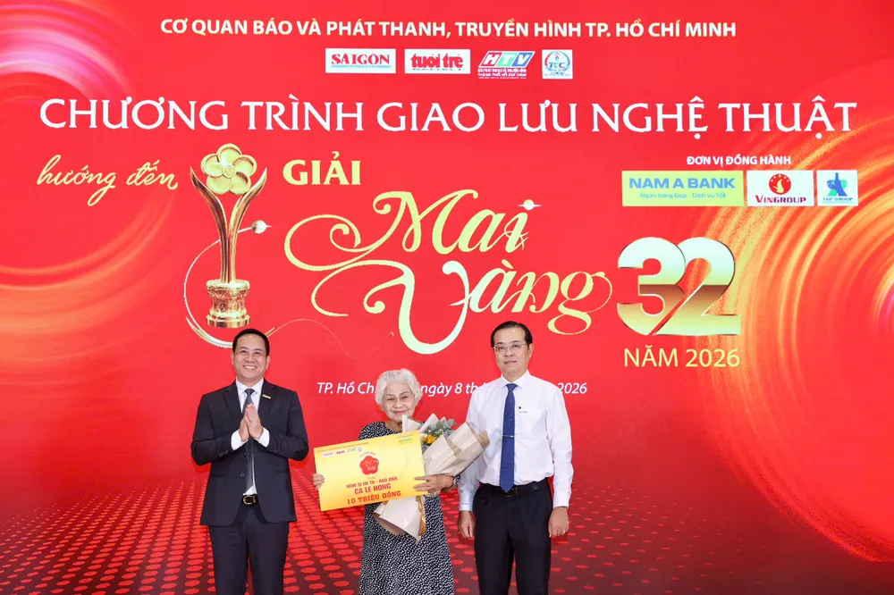 Đồng chí Lê Văn Minh, Thành ủy viên, Tổng Giám đốc Cơ quan Báo và Phát thanh, Truyền hình TP.HCM, Trưởng Ban Chỉ đạo Giải Mai Vàng lần thứ 32 – năm 2026 và ông Hà Huy Cường - Phó Tổng Giám đốc Ngân hàng TMCP Nam Á trao phần thưởng Mai Vàng tri ân cho NSƯT đạo diễn Ca Lê Hồng. Ảnh: HOÀNG TRIỀU