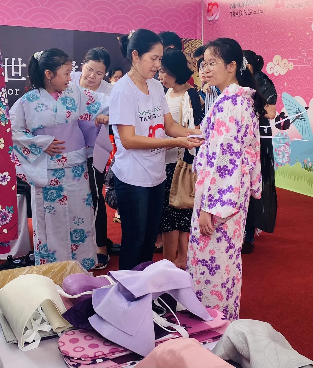 Các bạn trẻ Việt Nam thích thú mặc Kimono tại các gian hàng trong chương trình Giao lưu văn hóa - thương mại Việt Nam - Nhật Bản sáng 17-6, tại Công viên Lưu Hữu Phước