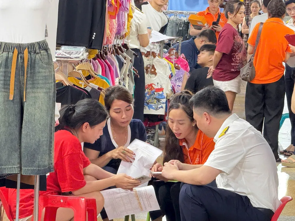 Cán bộ thuế hướng dẫn cho các cá nhân và hộ kinh doanh thủ tục tự kê khai và thực hiện nghĩa vụ thuế sau khi bỏ thuế khoán. Ảnh: CT