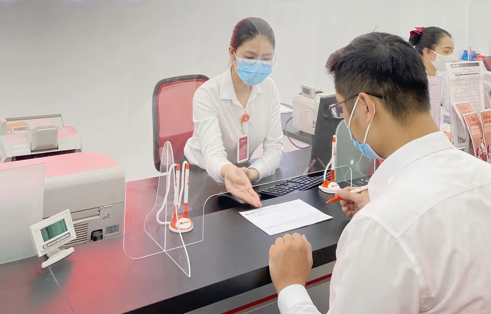 Khách hàng giao dịch tại ngân hàng.  Ảnh: Minh Huy