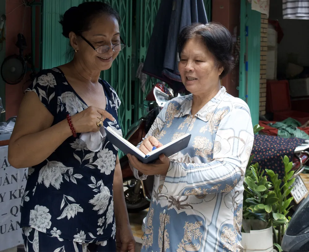 Bí thư chi bộ đồng thời là Trưởng khu phố 4, phường 1, quận 3  Nguyễn Thị Chiếm (bên phải) trao đổi với người dân trong khu phố