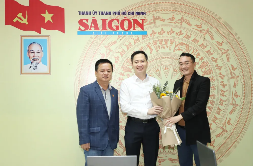 Đại diện Báo SGGP tặng hoa cho ông Nguyễn Thiện Nghĩa, Phó Cục trưởng Cục Công nghiệp CNTT và TT (Bộ TT-TT) tại Văn phòng đại diện Báo SGGP tại Hà Nội. Ảnh: QUANG PHÚC