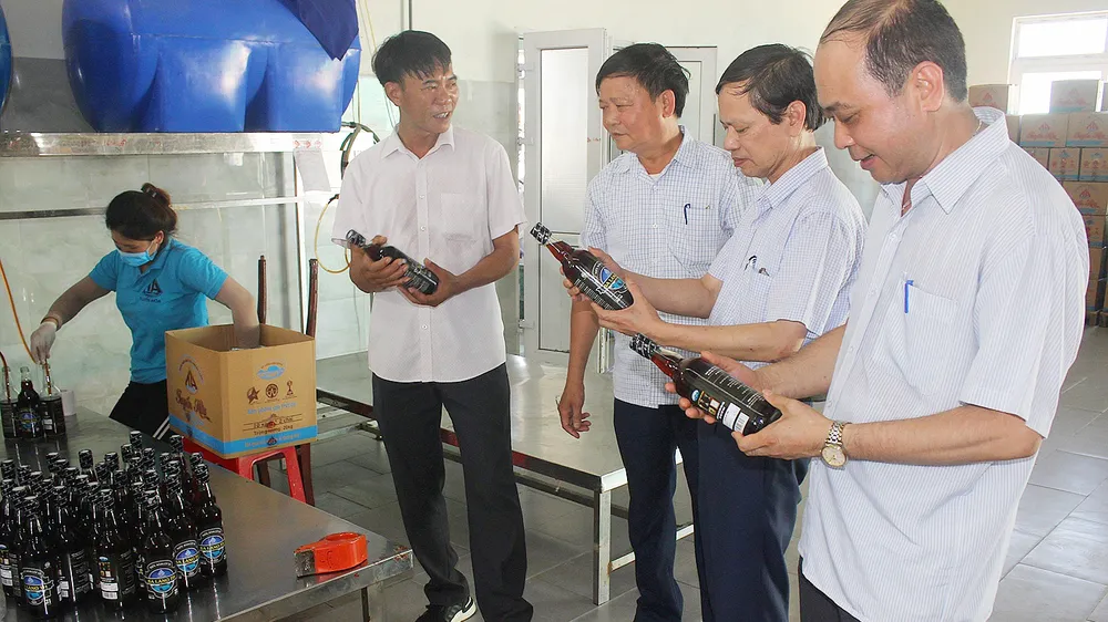 Anh Nguyễn Văn Tuyến (thứ hai, từ trái sang) giới thiệu sản phẩm nước mắm Ba Làng với khách hàng