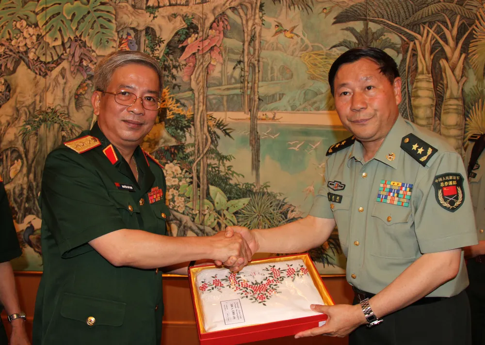 Thượng tướng Nguyễn Chí Vịnh tặng quà lưu niệm cho Trung tướng Thích Kiến Quốc, Phó Tổng Tham mưu trưởng Quân giải phóng nhân dân Trung Quốc tại Đối thoại chiến lược quốc phòng Việt Nam - Trung Quốc 2013 ở Bắc Kinh. Ảnh: YÊN BA