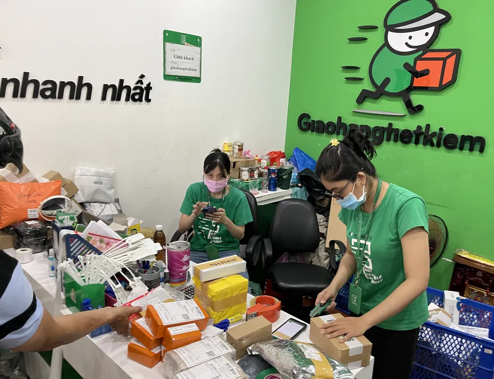 Nhân viên Trung tâm Giao nhận hàng tiết kiệm (trên đường Nguyễn Văn Cừ, quận 1, TPHCM) phân loại hàng để giao cho shipper. Ảnh: HOÀNG HÙNG