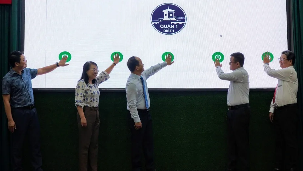 Lãnh đạo UBND quận 1 thực hiện nghi thức ra mắt phần mềm “Tra cứu và đăng ký sử dụng tạm thời một phần hè phố quận 1". Ảnh: THU HƯỜNG