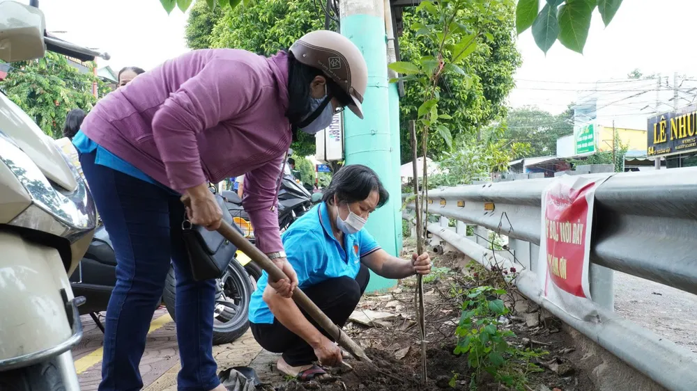 Người dân TP Dĩ An trồng cây xanh trên tuyến đường Lý Thường Kiệt góp phần xây dựng nếp sống văn minh.jpg