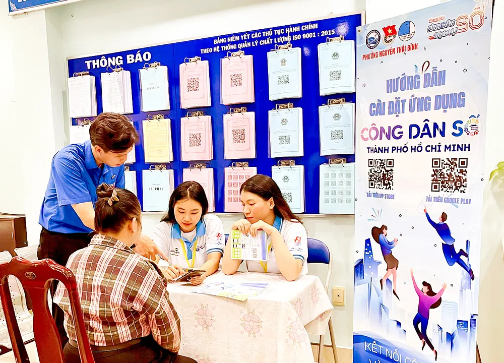 Các tình nguyện viên hướng dẫn người dân cài đặt ứng dụng Công dân số TPHCM tại UBND phường Nguyễn Thái Bình (quận 1, TPHCM)