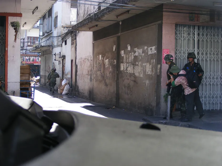 Nhà báo Chiến Dũng (áo caro) theo chân lực lượng quân đội Thái Lan truy tìm những tay bắn tỉa trên đường phố Bangkok, năm 2010. Ảnh: ĐỖ VĂN