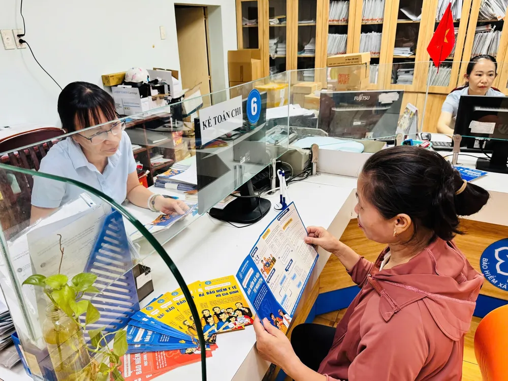 Viên chức BHXH TPHCM tư vấn chính sách BHXH cho người dân. Ảnh: ĐÔNG SƠN