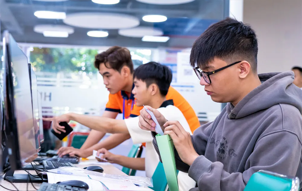 Cán bộ tuyển sinh Trường ĐH Công nghệ TPHCM hướng dẫn thí sinh nộp lệ phí xét tuyển trên Hệ thống tuyển sinh của Bộ GD-ĐT. Ảnh: THANH HÙNG