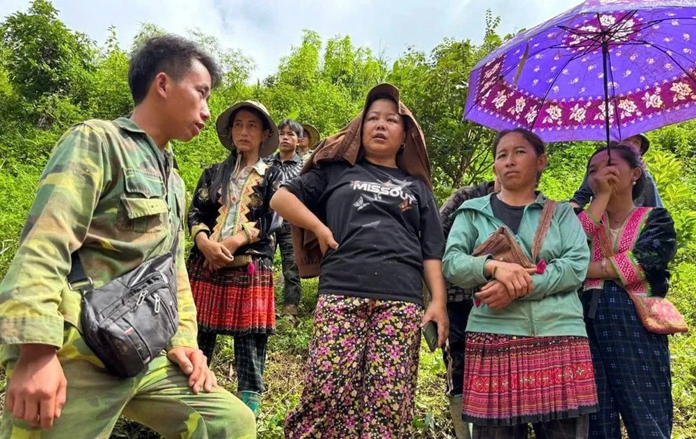 Trưởng bản Mùa A Thi (bìa trái) trao đổi với bà con thoát nạn lũ quét