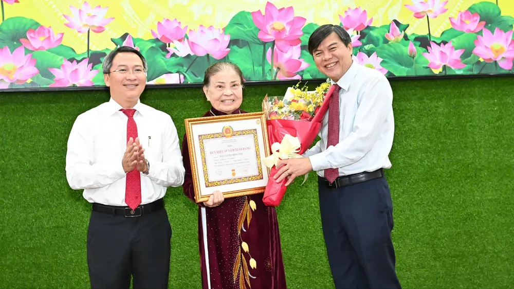 Đồng chí Tăng Hữu Phong và đồng chí Nguyễn Tấn Phát trao Huy hiệu 65 năm tuổi Đảng đến đảng viên phường Sài Gòn. Ảnh: VIỆT DŨNG