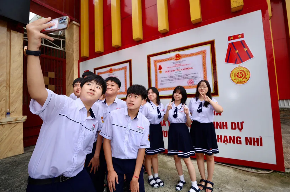 Học sinh lớp 10A5 Trường THCS-THPT Hồng Hà (TPHCM) phấn khởi check -in trước giờ khai giảng. Ảnh: DŨNG PHƯƠNG