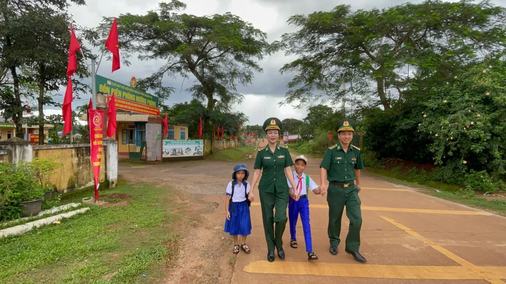 Thiếu tá Nguyễn Thị Vân, Bộ đội Biên phòng tỉnh Quảng Trị là “mẹ nuôi” cháu Mai Thị Như Tuyền và Mai Quốc Tuấn (học sinh Trường Tiểu học xã Hướng Phùng) theo Chương trình “Nâng bước em tới trường – Con nuôi đồn Biên phòng” đưa các con đi khai giảng. Ảnh: VĂN THẮNG