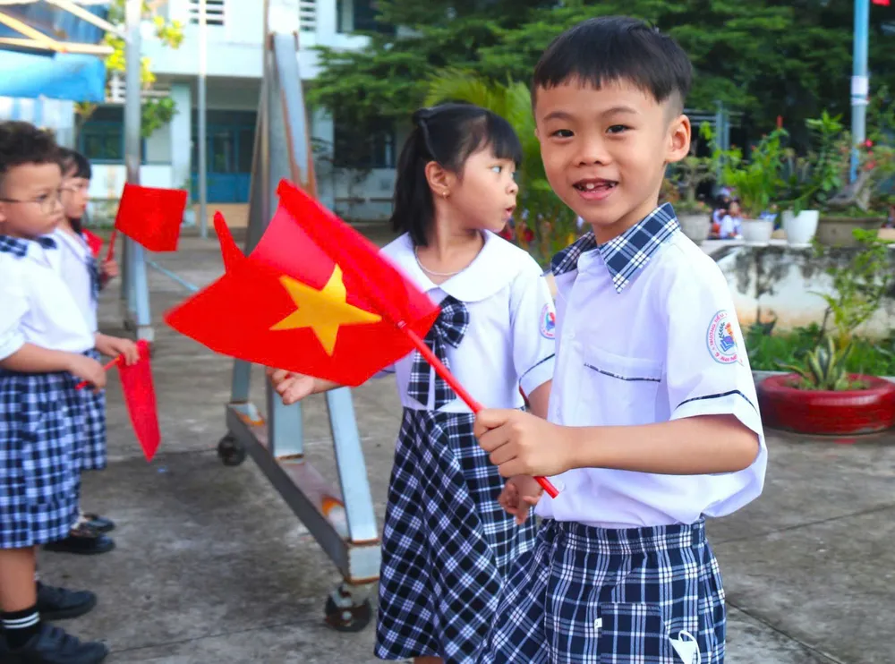 Học sinh lớp 1, Trường Tiểu học Xuân An (Lâm Đồng) thích thú khi lần đầu tiên dự lễ khai giảng. Ảnh: NGUYỄN TIẾN