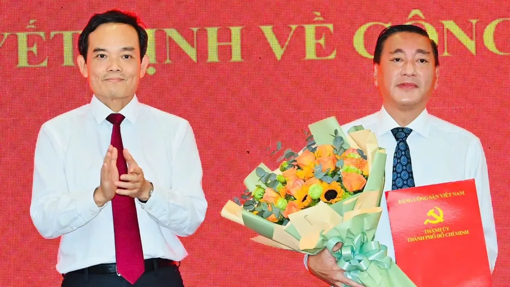 Bí thư Thành ủy TPHCM Trần Lưu Quang trao quyết định cho đồng chí Phạm Thành Kiên. Ảnh: VIỆT DŨNG