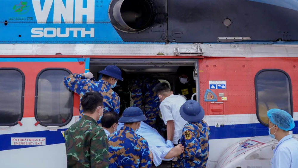 Các cán bộ chiến sĩ đảo Sinh Tồn (đặc khu Trường Sa) vận chuyển người bệnh lên trực thăng về đất liền