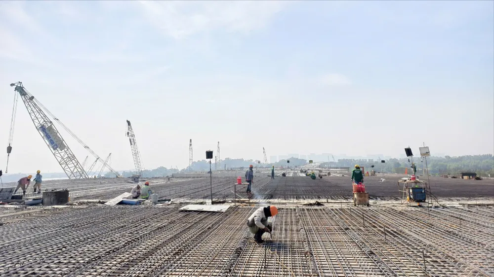 Công nhân, kỹ sư đang thi công gói thầu XL5, dự án đường Vành đai 3. Ảnh: QUỐC HÙNG 