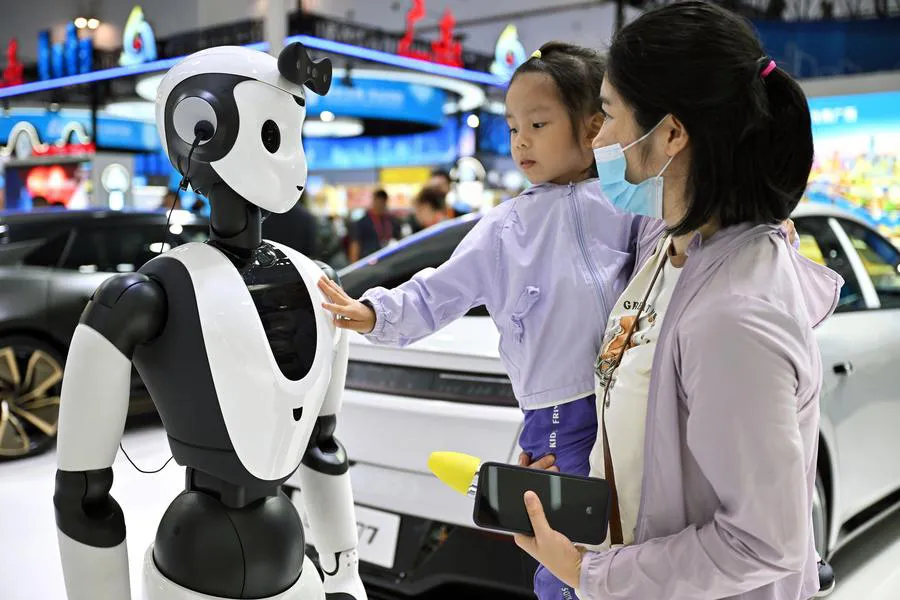 Người dân tương tác robot AI tại Triển lãm tiêu dùng quốc tế Trung Quốc. Ảnh: XINHUA 