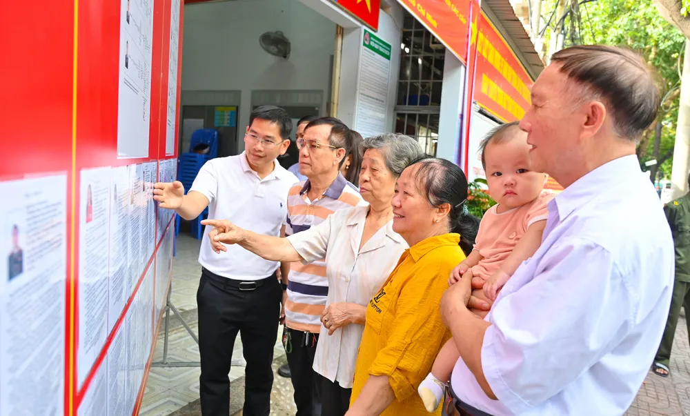 Lãnh đạo địa phương cùng các thành viên Tổ bầu cử Khu vực bầu cử số 30 phường Tam Thắng, cùng cử tri địa phương theo dõi thông tin tiểu sử các ứng cử viên