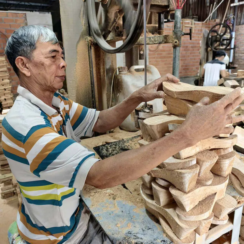  Ông Nguyễn Văn Sụ (64 tuổi) tạo hình những đôi guốc thô 