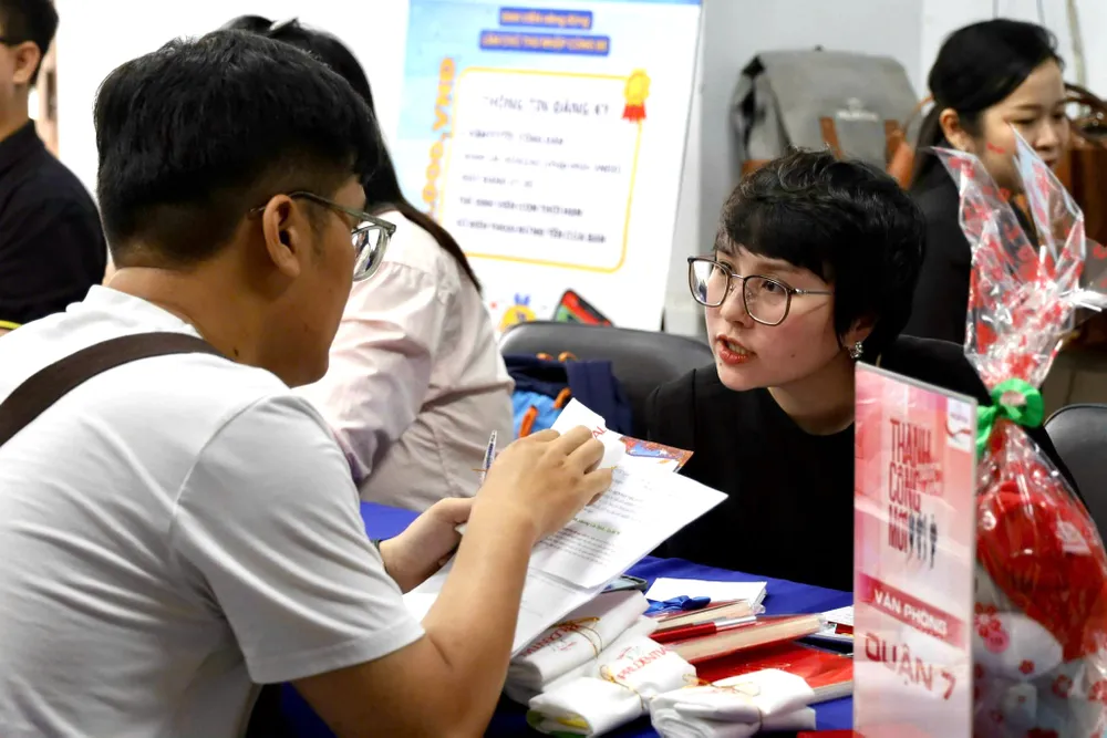 Người lao động tìm hiểu thông tin tuyển dụng tại một ngày hội việc làm được tổ chức ở TPHCM. ẢNH: HUỲNH NHƯ