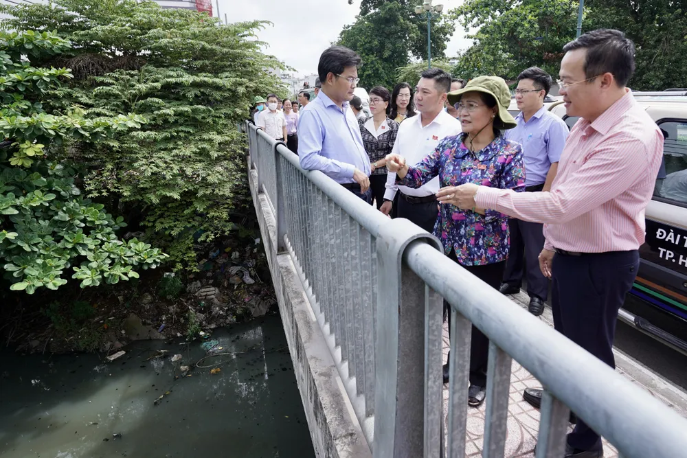 Đồng chí Nguyễn Thị Lệ giám sát tiến độ triển khai thực hiện dự án nạo vét, cải tạo môi trường, xây dựng hạ tầng rạch Xuyên Tâm trên cầu Băng Ky. Ảnh: HOÀNG HÙNG