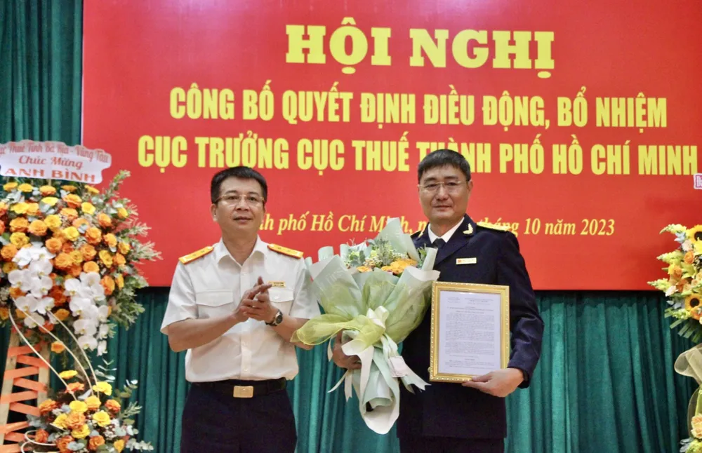 Tổng cục trưởng Tổng Cục Thuế Mai Xuân Thành trao quyết định và hoa chúc mừng ông Nguyễn Nam Bình (phải). Ảnh: MAI HOA Tổng cục trưởng Tổng Cục Thuế Mai Xuân Thành trao quyết định và hoa chúc mừng ông Nguyễn Nam Bình (phải). Ảnh: MAI HOA