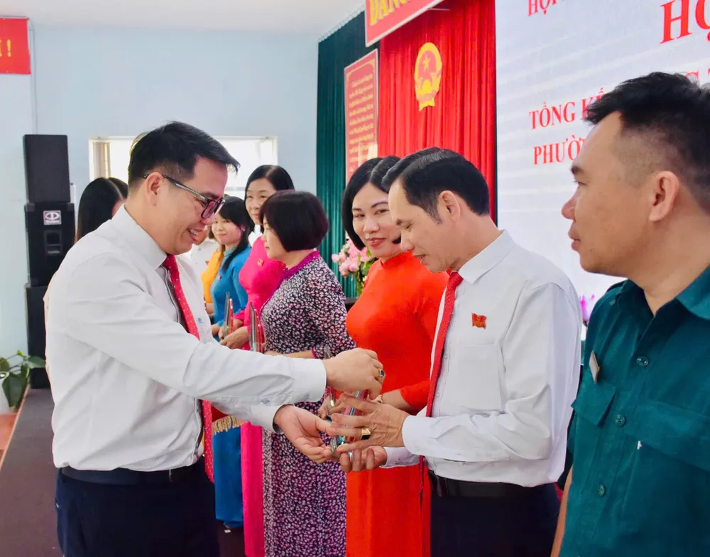 Đồng chí Nguyễn Chí Linh, Phó Bí thư Thường trực Đảng ủy phường Tam Thắng trao quà lưu niệm cho các đại biểu HĐND phường.