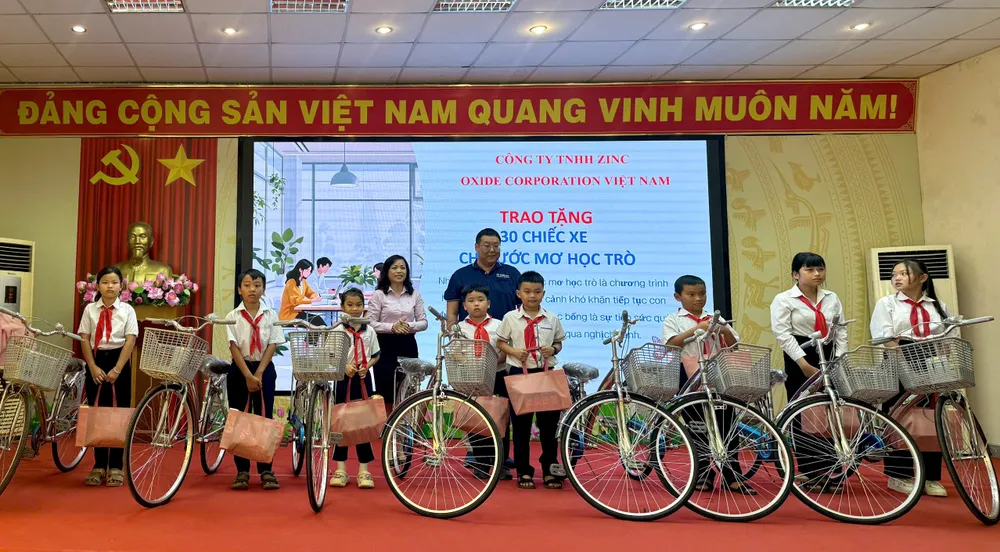 Đại diện Công ty TNHH Zinc Oxide Corporation Việt Nam trao xe đạp cho các em học sinh khó khăn