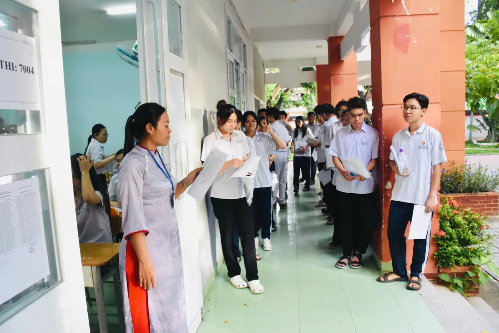 Giám thị gọi tên thí sinh vào phòng thi tại điểm thi THCS Trần Phú (phường Tam Thắng, TPHCM). Ảnh: KHÁNH CHI