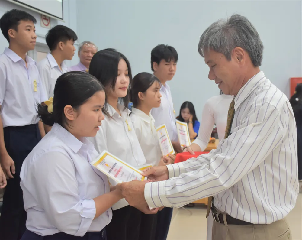 Ông Hồ Cảnh Hạnh, Phó Chủ tịch Hội Khuyến học TPHCM trao học bổng cho các em học sinh.