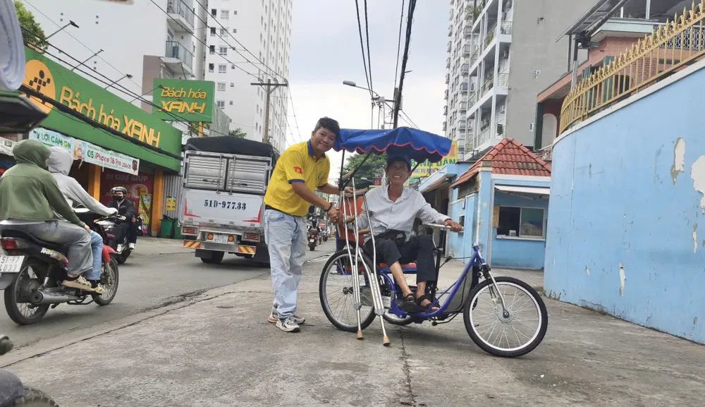 Anh Lê Khắc Dũng, Chủ nhiệm Câu lạc bộ thiện nguyện Vì nụ cười trẻ thơ 72 trao xe lắc tay cho anh Lê Văn Đức
