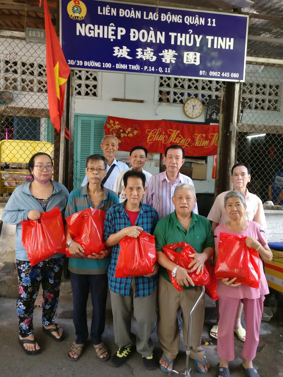 玻璃业团负责人李国强和热心厂商杨庆文等人向团员派发新年礼物后合照。