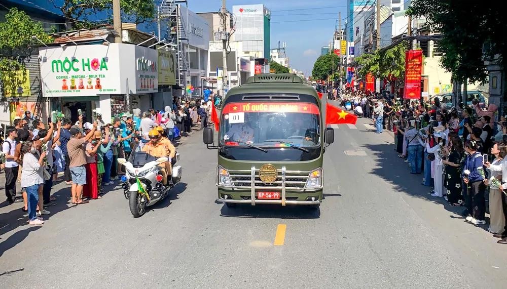 车队途经各条道路，沿途众多民众怀着崇敬与感恩之情，向烈士致以深切哀悼。图片：孟胜