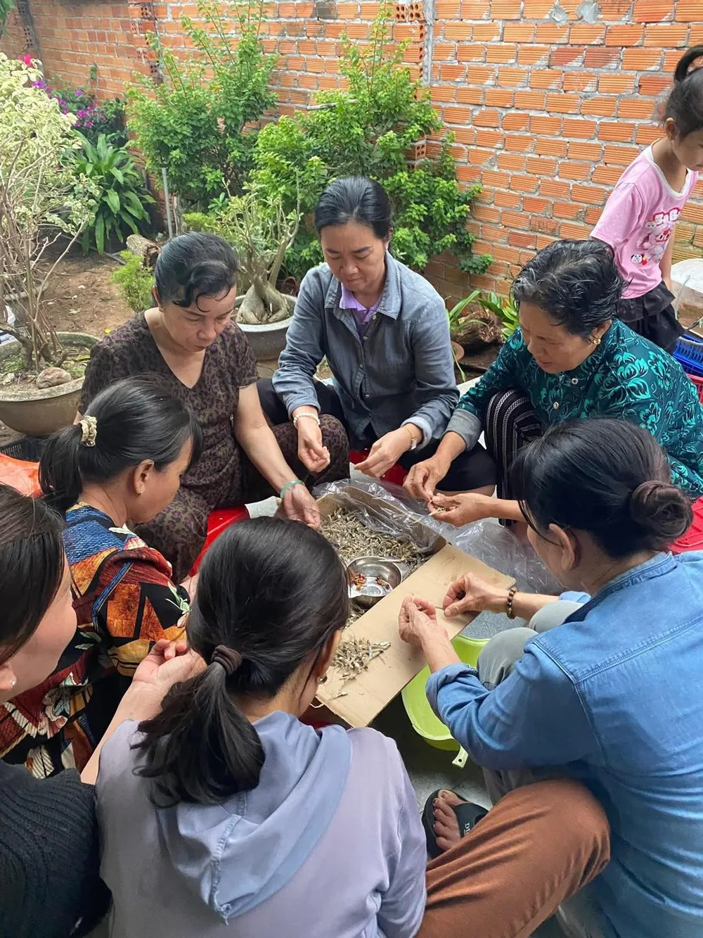 Người dân xã Bình Châu làm cá khô rim đậu phộng, đóng gói hút chân không để làm lương thực gửi bà con vùng lũ. Ảnh: BÌNH CHÂU