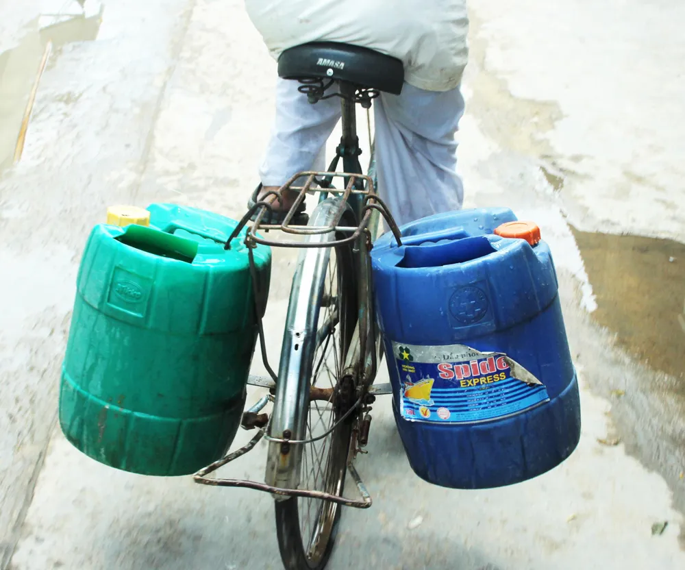 Xe đạp chở từng can nước sạch về nhà.