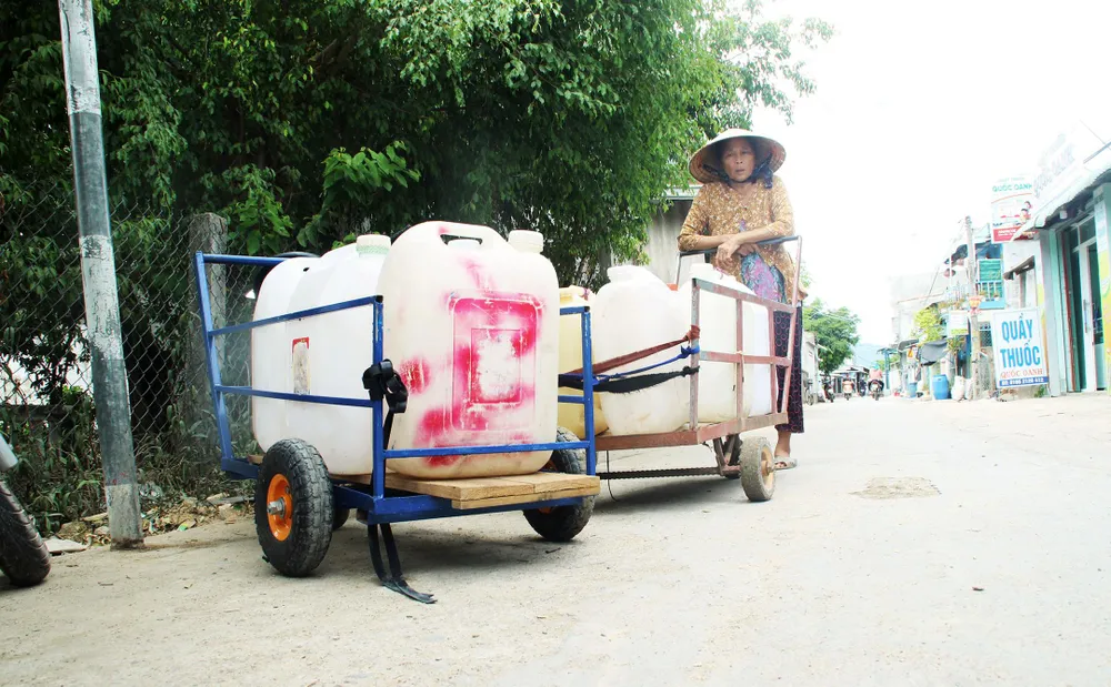 Người dân xã Phước Thuận (huyện Tuy Phước) sắp hàng chờ đợi để tiếp nhận nước miễn phí từ các xe chữa cháy.