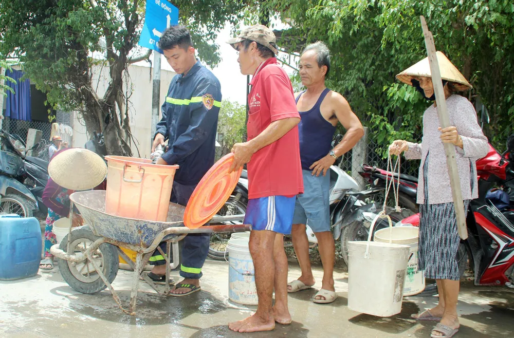 Chiến sĩ thuộc Cảnh sát PCCC-CNCH (Công an tỉnh Bình Định) tiếp nước, cứu hạn cho người dân vùng trọng điểm hạn huyện Tuy Phước, tỉnh Bình Định.
