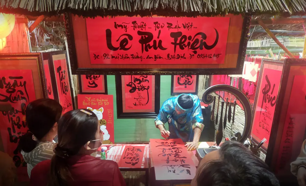 Ông đồ viết tranh thư pháp chúc Tết tại lễ hội. Ảnh: NGỌC OAI Ông đồ viết tranh thư pháp chúc Tết tại lễ hội. Ảnh: NGỌC OAI