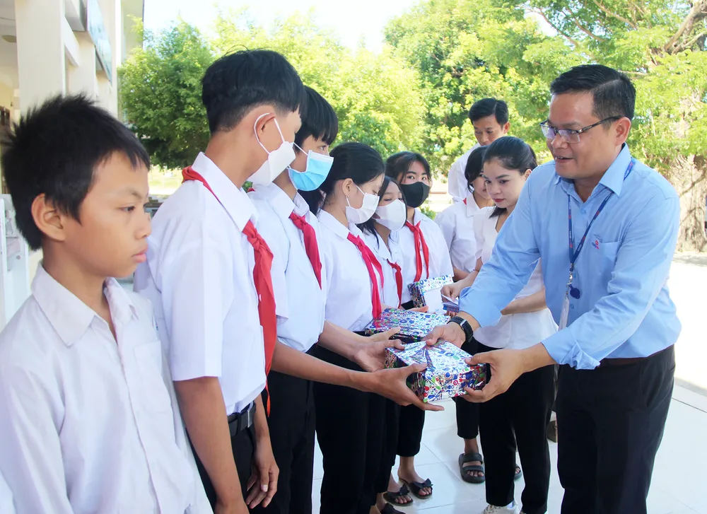 Đại diện siêu thị Co.opmart Quy Nhơn trao quà cho các em học sinh