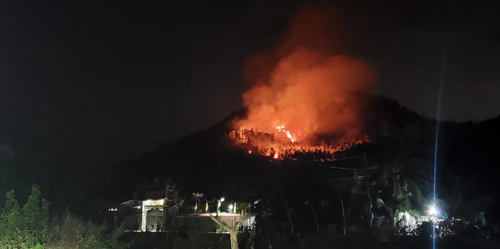 Quả đồi bùng cháy dữ dội nằm sát khu dân cư. Ảnh: NGỌC OAI