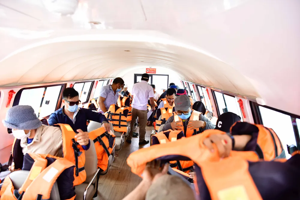 Người dân ở đảo Nhơn Châu lên ca nô để được đưa đón về đảo