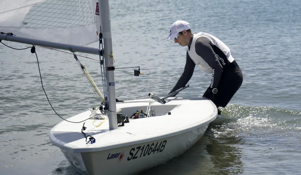 Vận động viên quốc tế đưa thuyền buồm xuống bãi biển chuẩn bị cho giải đấu