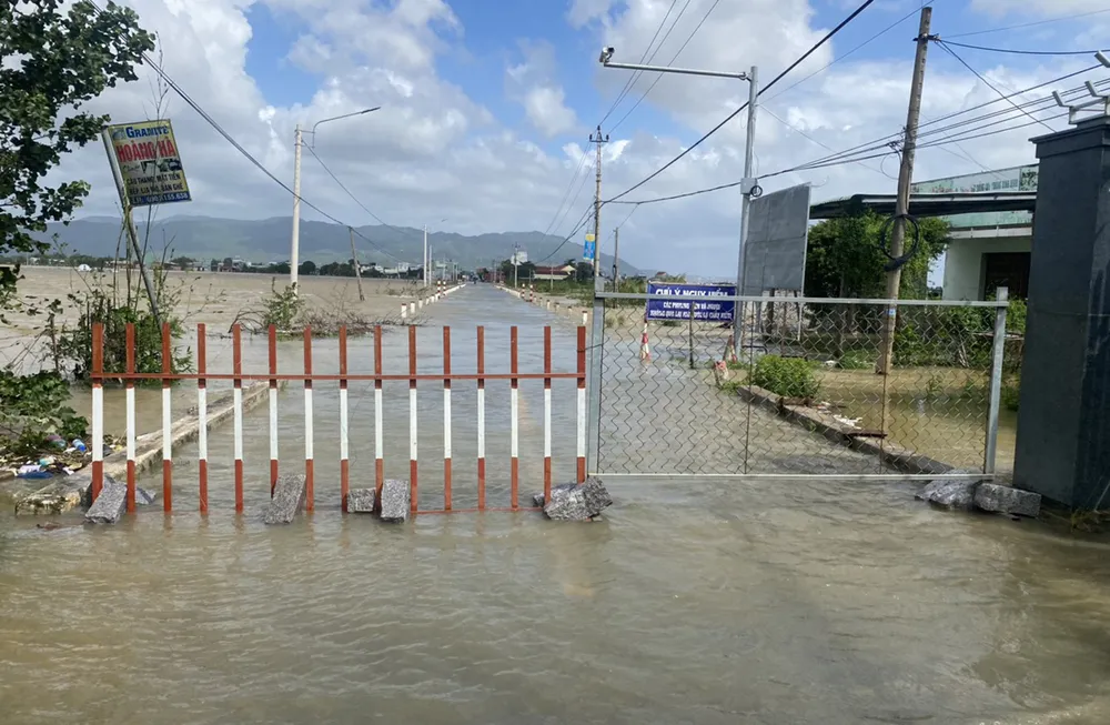 Lực lượng chức năng ở huyện Tuy Phước rào chắn các điểm đường ngập lũ. Ảnh: NGỌC OAI